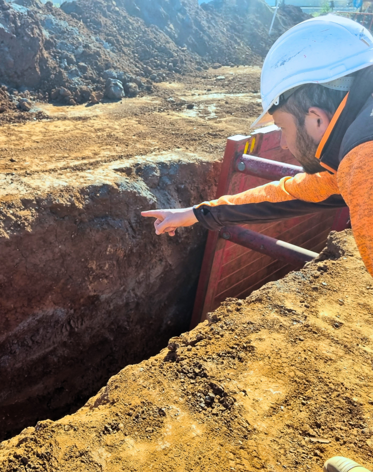 Dani pointing to a trench